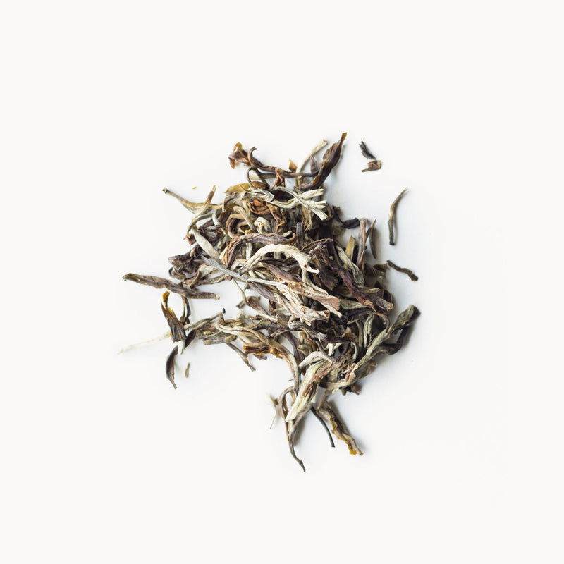 A pile of dried Moonlight Jasmine tea from Rishi Tea & Botanicals on a white background.